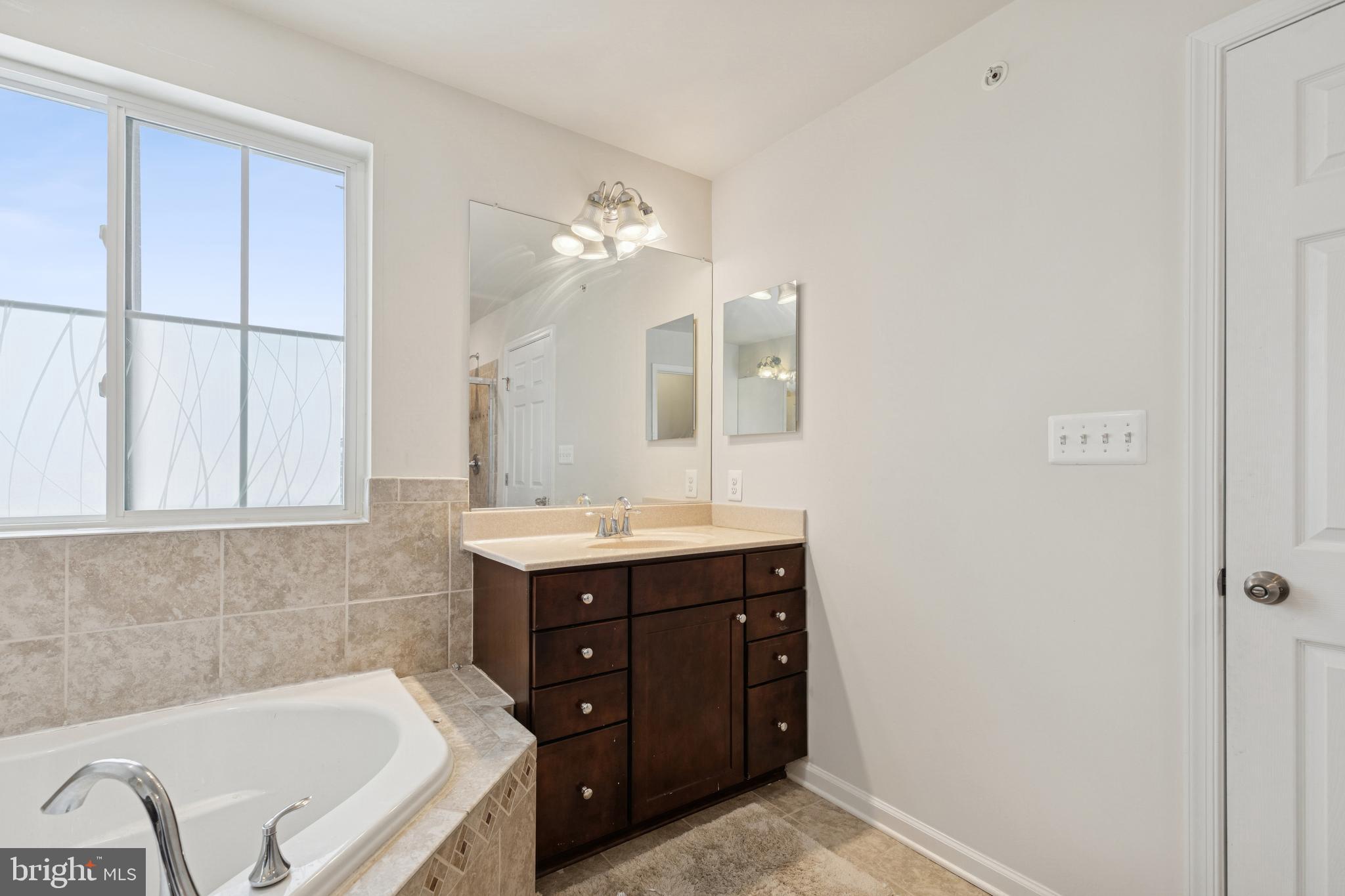 5857 Bella Marie Way, Unit F Frederick, MD 21703 - Photo 36 of 45 a bathroom with a tub sink and mirror