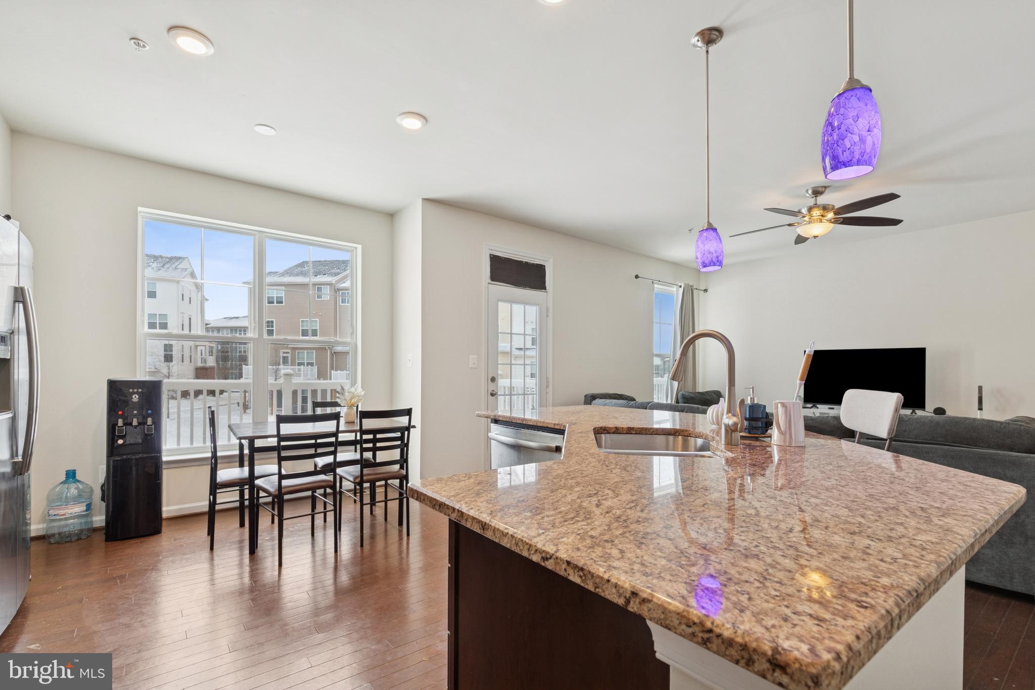 5857 Bella Marie Way, Unit F Frederick, MD 21703 - Photo 10 of 45 a kitchen with kitchen island granite countertop a table and chairs in it