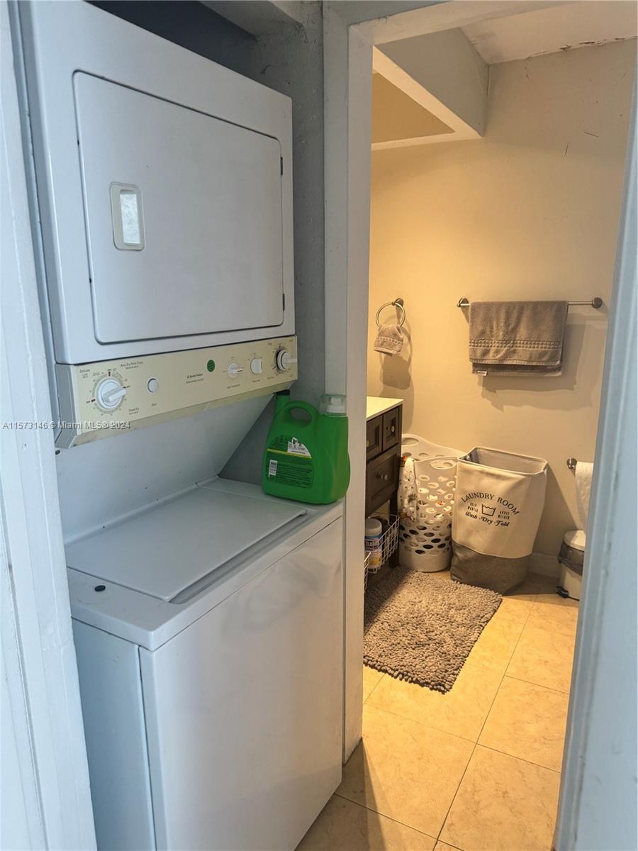 7580 Southwest 82nd Street, Unit F217 Miami, FL 33143 - Photo 6 of 14 a living room with a washer and dryer
