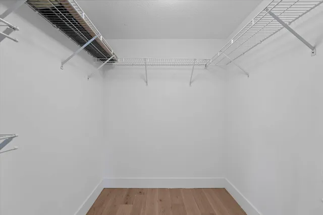 a view of walk in closet with racks on the wall