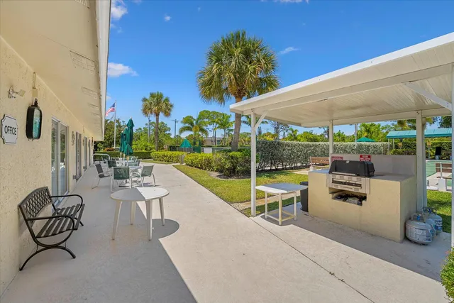 a view of a patio with a table and chairs under an umbrella