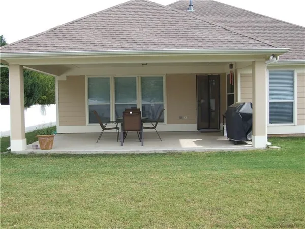 a view of a house with patio and a yard