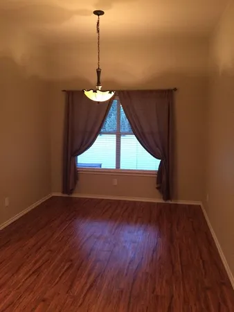 a view of a room with wooden floor a sink and a window