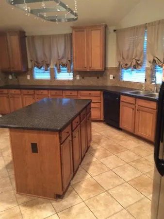 a kitchen with stainless steel appliances granite countertop a stove a sink a counter space and cabinets