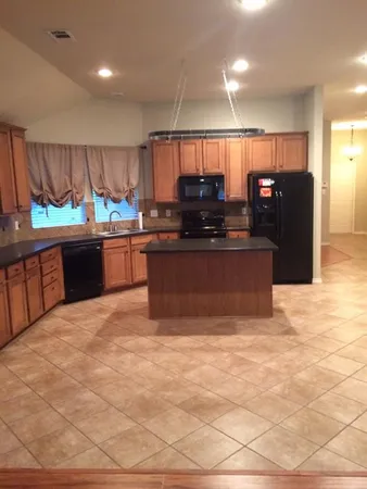 a large kitchen with stainless steel appliances granite countertop a sink and a stove