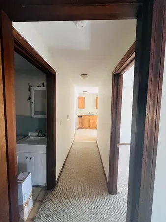 a view of a hallway and a bathroom with a sink