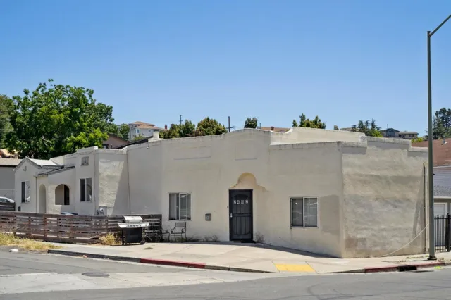 a view of a white building among the street and palm trees