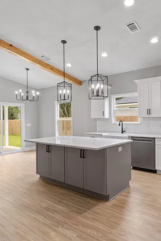 a large kitchen with kitchen island a chandelier wooden floor and a chandelier