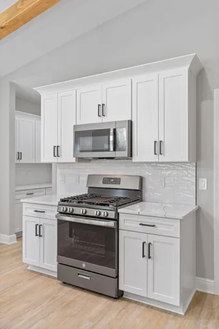 a kitchen with white cabinets and appliances
