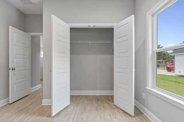 an empty room with wooden floor and windows