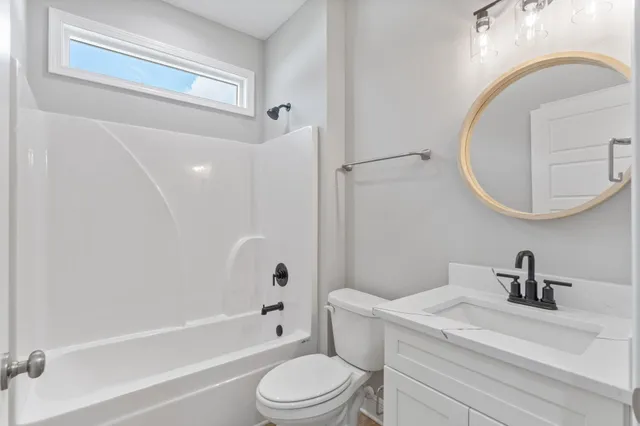a bathroom with a toilet a sink a mirror and bathtub