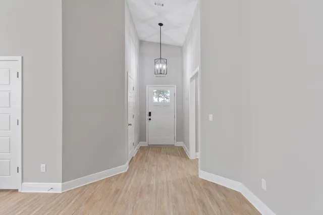 a view of a hallway with wooden floor and closet
