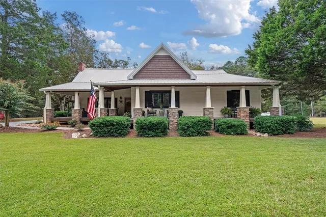 a front view of a house with porch and garden