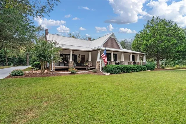 a view of a house with backyard garden and sitting area