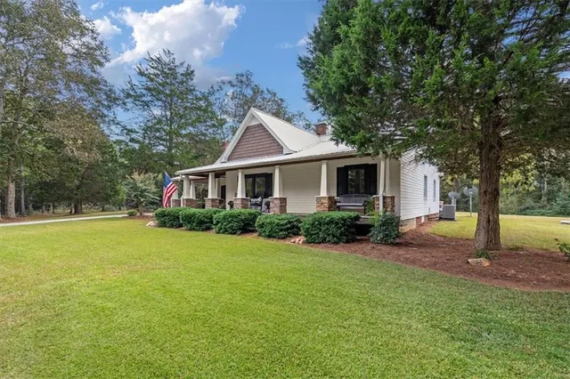 a view of a house with backyard and sitting area