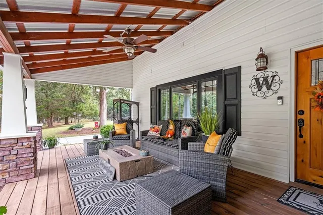 a view of a patio with table and chairs potted plants with wooden floor and fence