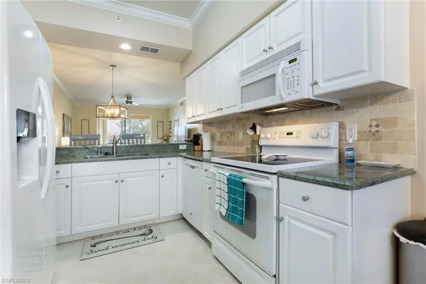 a kitchen with granite countertop white cabinets stainless steel appliances and sink