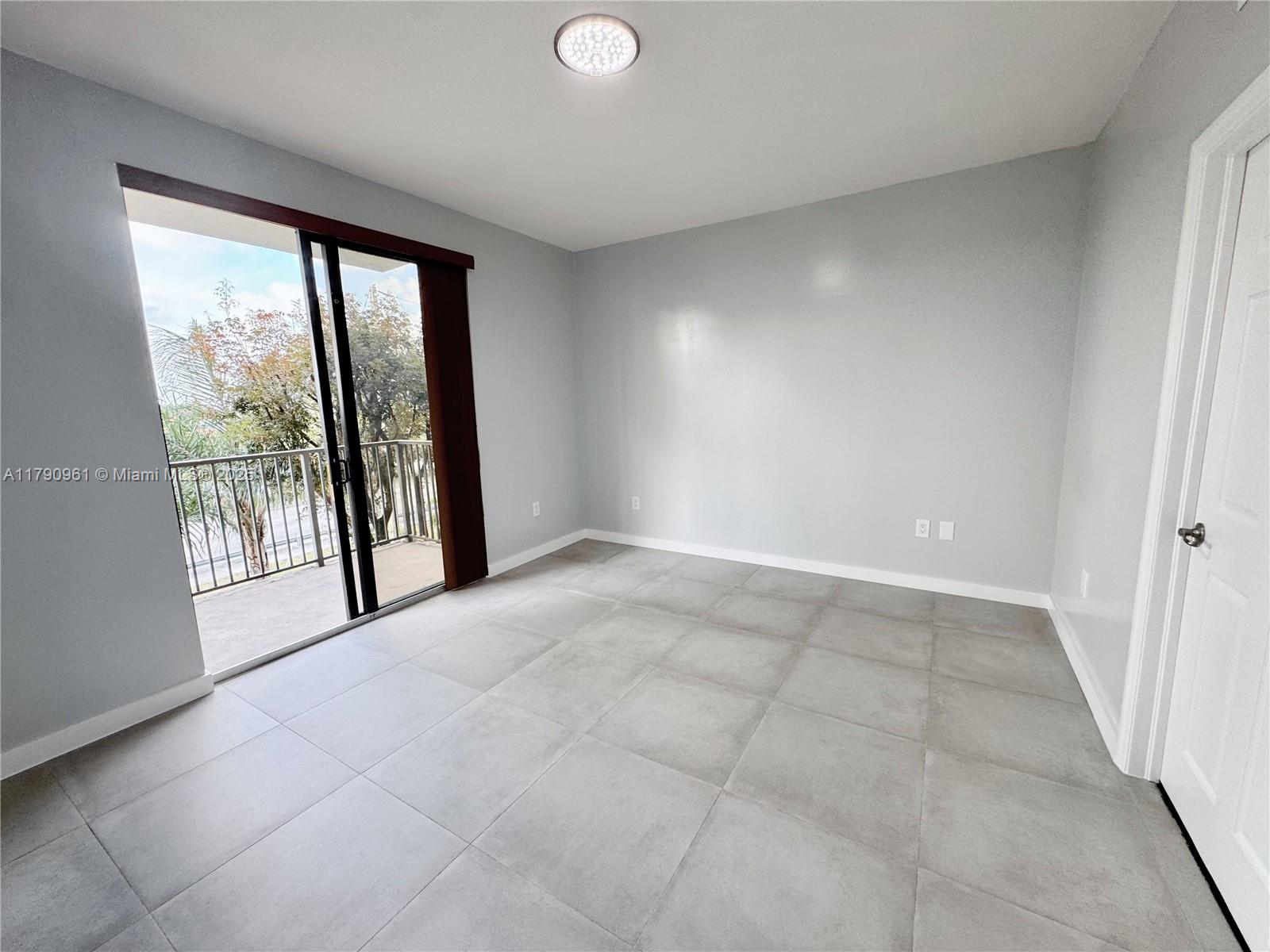 8440 Southwest 8th Street, Unit 304A Miami, FL 33144 - Photo 13 of 21 an empty room with windows and city view