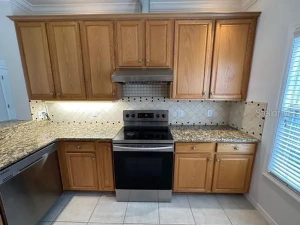 a large kitchen with stainless steel appliances granite countertop a refrigerator and a sink