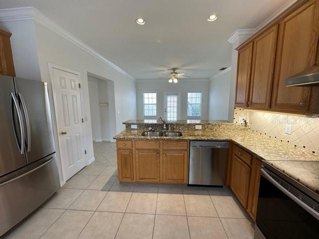 1005 Wiregrass Street Celebration, FL 34747 - Photo 9 of 31 a large kitchen with stainless steel appliances granite countertop a refrigerator and a sink