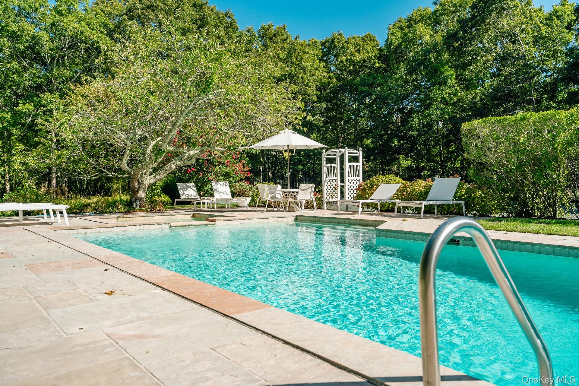 30 Pheasant Run Quogue, NY 11959 - Photo 20 of 26 a view of a swimming pool with a patio