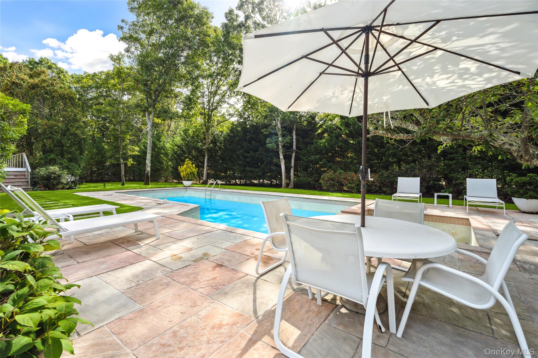 30 Pheasant Run Quogue, NY 11959 - Photo 2 of 26 a view of a swimming pool with a patio