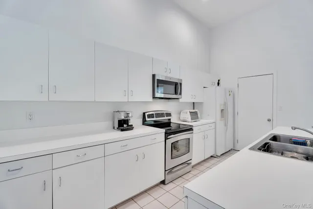 a kitchen with white cabinets and white appliances