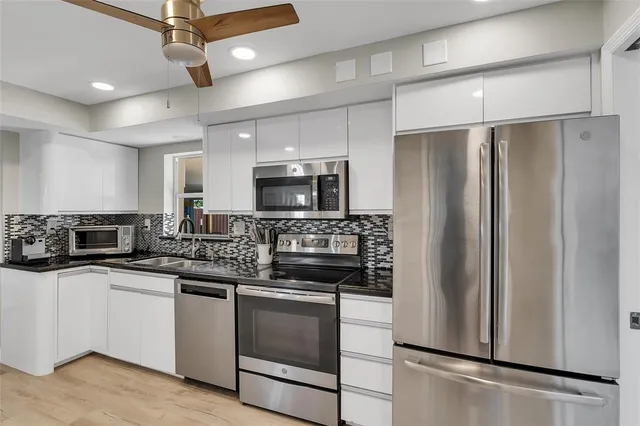 a kitchen with stainless steel appliances a refrigerator sink and microwave
