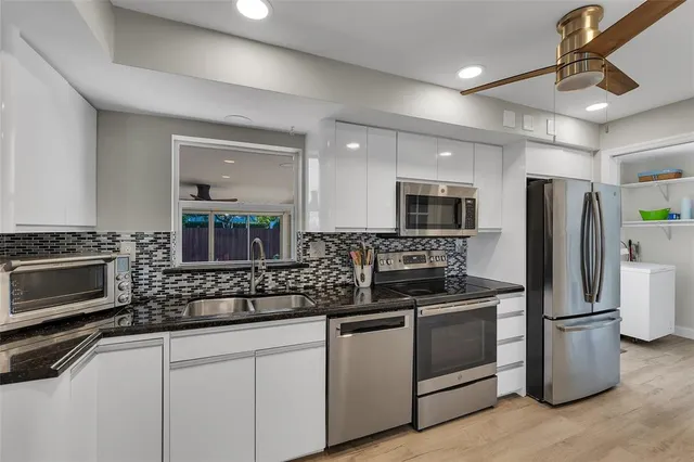a kitchen with refrigerator a microwave a stove and cabinets
