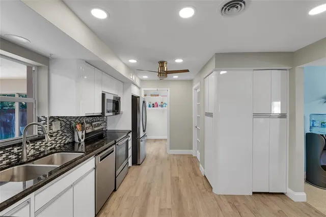 a kitchen with stainless steel appliances granite countertop a refrigerator and a sink