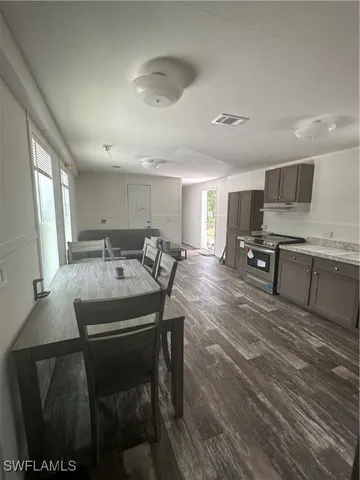 a kitchen with a table chairs microwave and cabinets