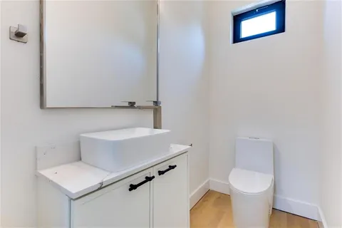 a white toilet sitting next to a white sink and vanity