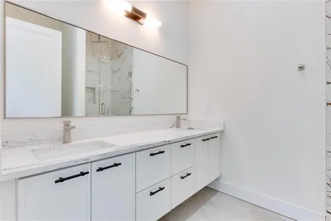 a bathroom with a double vanity sink and a mirror