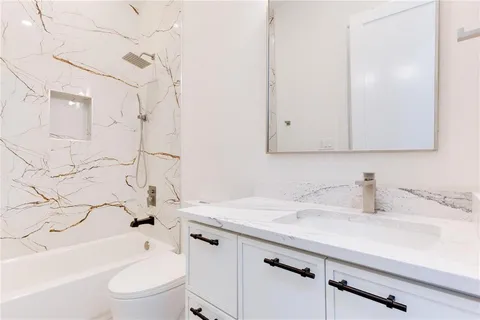 a bathroom with a sink toilet vanity and bathtub