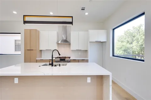 a kitchen with kitchen island a sink appliances and a counter top space