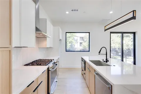 a kitchen with stainless steel appliances a sink stove and cabinets