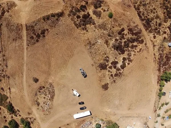a view of a dry yard with mountains in the background