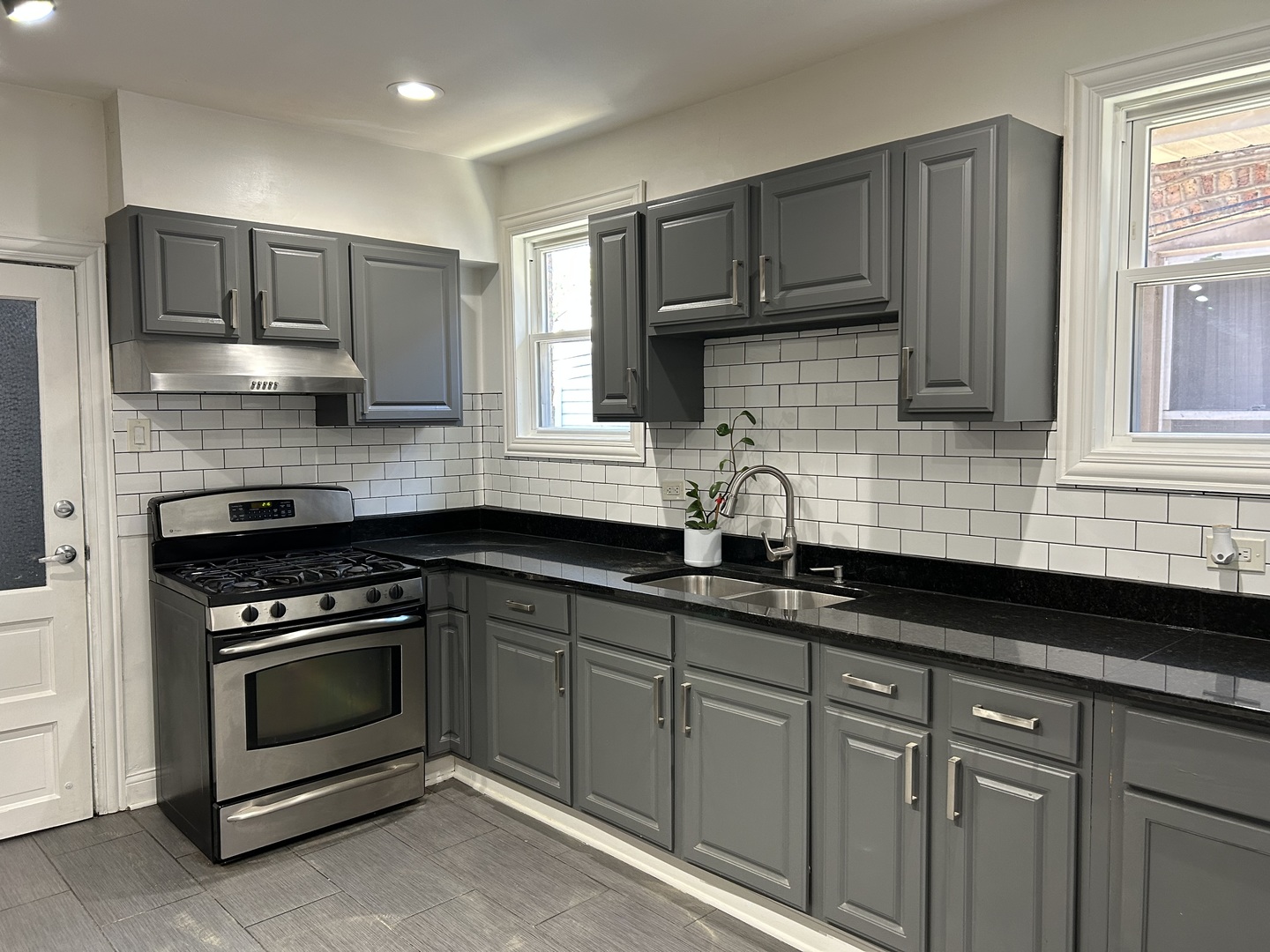4858 West Concord Place, Unit 1 Chicago, IL 60639 - Photo 6 of 14 a kitchen with granite countertop cabinets stainless steel appliances and a sink