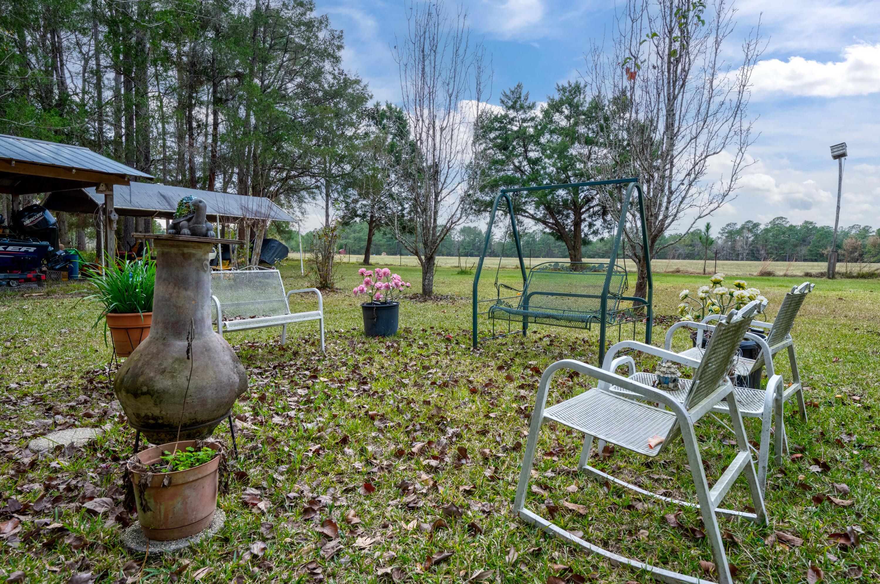 248 Bunny Lane Freeport, FL 32439 - Photo 23 of 27 a view of a patio with table and chairs potted plants with large tree