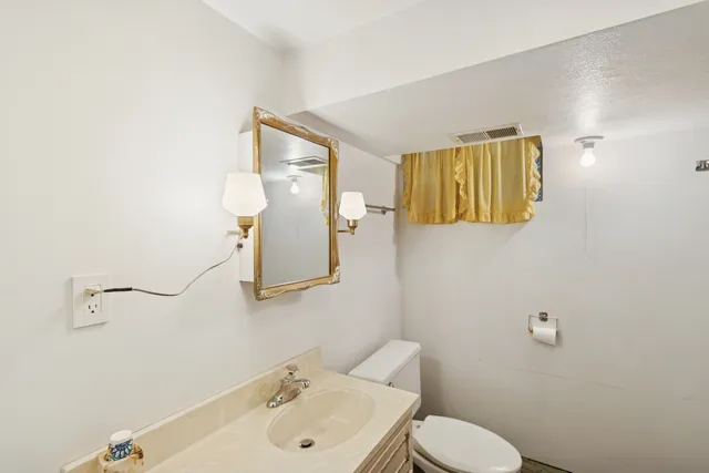 a bathroom with a sink and mirror with toilet