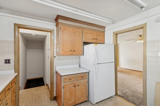 a white refrigerator freezer and a stove sitting inside of a kitchen