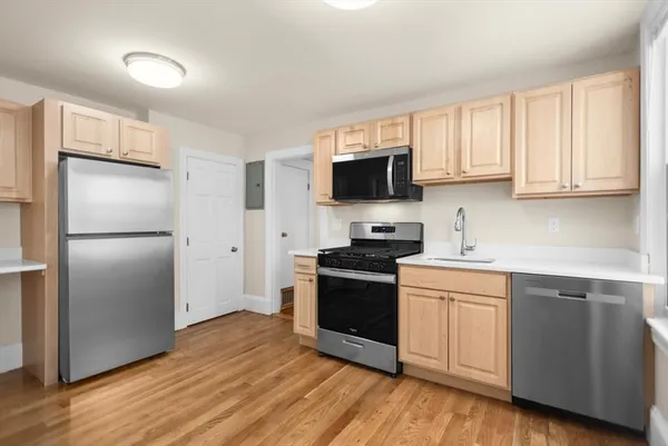 a kitchen with a refrigerator stove and wooden cabinets