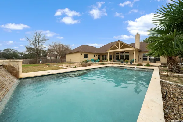 a view of a house with a yard and swimming pool