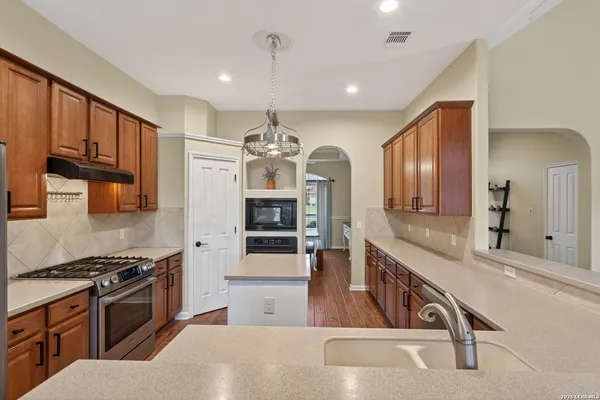 a large kitchen with stainless steel appliances granite countertop a stove and a sink