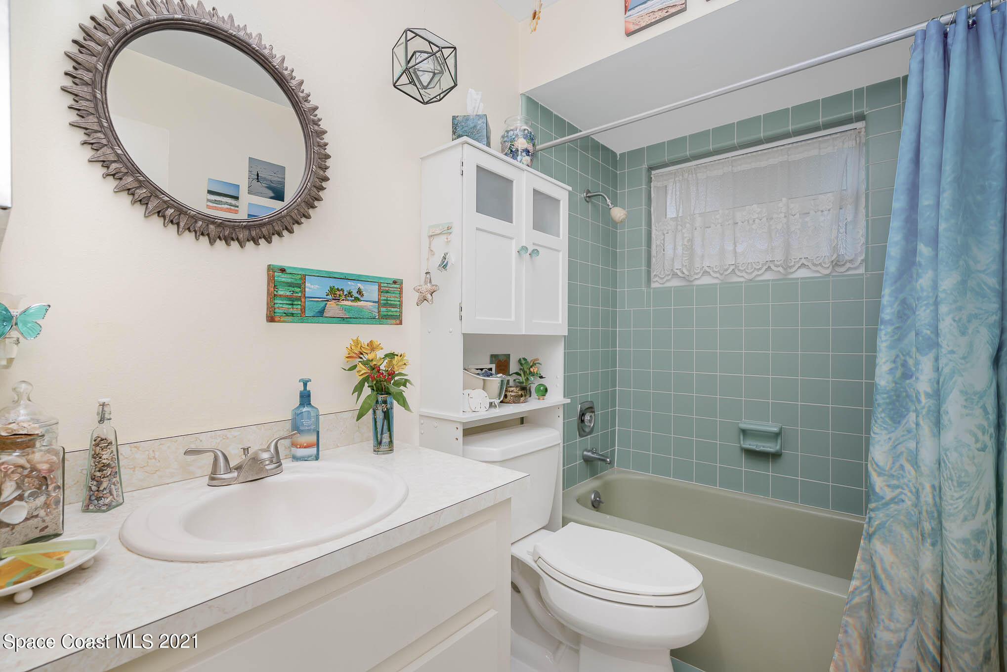 1291 Creel Road Northeast Palm Bay, FL 32905 - Photo 17 of 31 a bathroom with a sink a toilet and a mirror