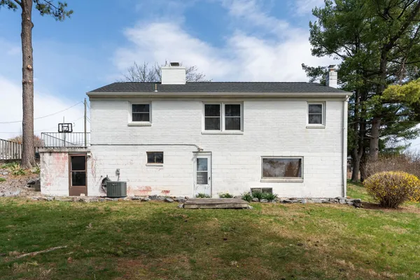 a white house that has tree in front of it