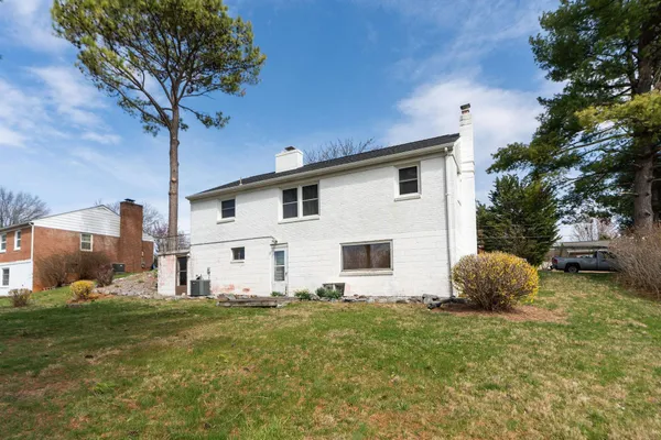 a view of a house with backyard and trees