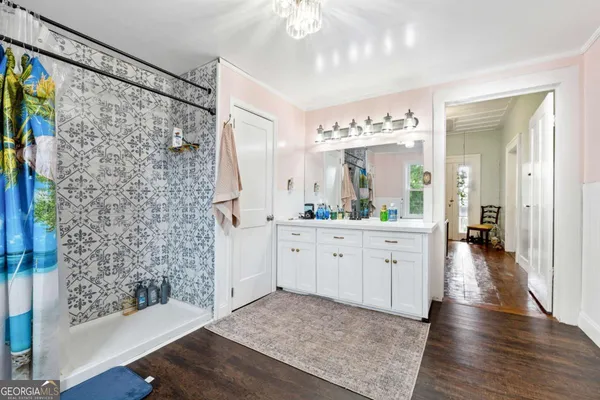 a spacious bathroom with a double vanity sink a large mirror a shower and a bathtub