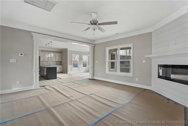 a view of an empty room with a fireplace and window