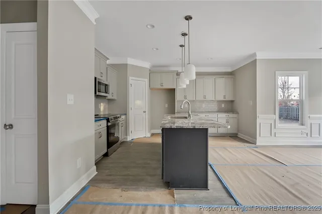 a kitchen with stainless steel appliances kitchen island granite countertop a refrigerator and a sink